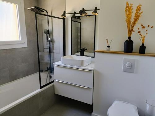 une salle de bain avec un lavabo blanc et une douche dans l'établissement Belle maison mitoyenne de standing, à Fréjus