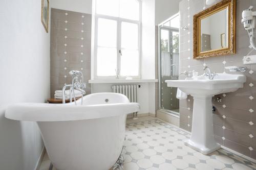 a bathroom with a white tub and a sink at Burbiskio dvaras in Anykščiai