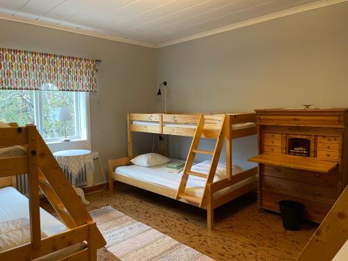 a bedroom with two bunk beds and a dresser at Jokkmokks Vandrarhem Åsgård in Jokkmokk