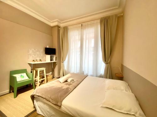 a bedroom with a bed and a desk and a window at Les Capitole I - Studio avec climatisation in Toulouse