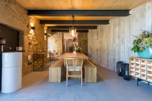 a kitchen with a wooden table and chairs in a room at in Bulla, Country and Wellness - Turismo Rural in Seixo do Côa