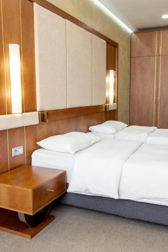 a bedroom with two beds and a table at Reikartz Sky Almaty in Almaty
