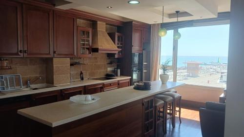 a kitchen with a counter and a large window at Quattro Sea View Beachfront Ap 6 in Larnaca