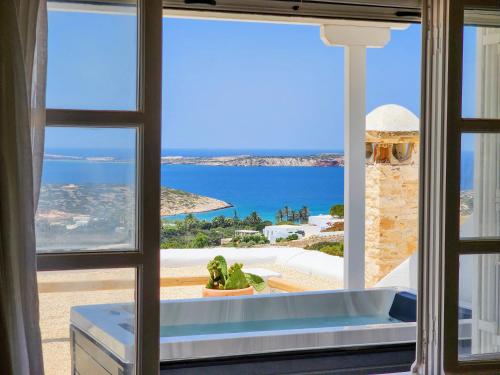 a view of the ocean from a room with a window at Anthemion Paros - Villas & Suites in Agia Irini Paros