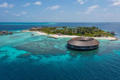 an island in the ocean with a building in the water at Kagi Maldives Resort & Spa in North Male Atoll