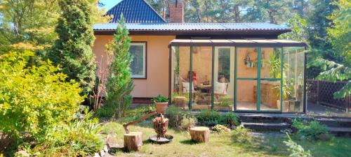 a house with a conservatory in a garden at Gästehaus Zur Walnuss Berlin in Blankenfelde