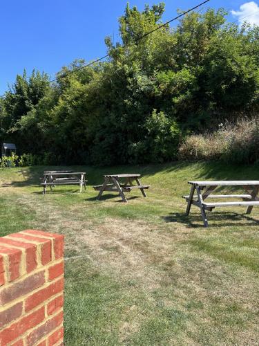 two picnic tables in the grass in a field at The Lydden Bell in Dover