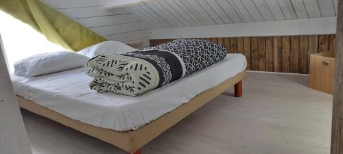 un letto con due cuscini sopra in una stanza di L escale jardin a Boussay