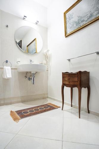 a bathroom with a sink and a mirror and a table at Burbiskio dvaras in Anykščiai