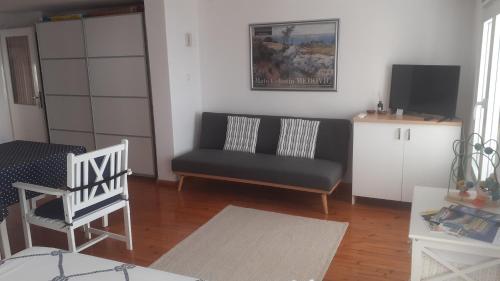 a living room with a couch and a chair at Studio with magic view in Podgora