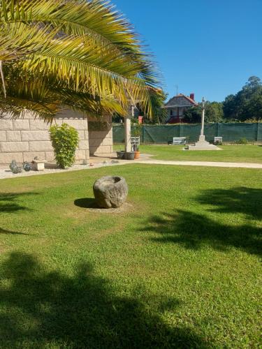 a rock sitting on the grass in a park at Os Cabaleiros in Mos