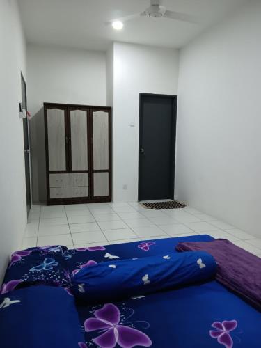 a bedroom with a blue bed with flowers on it at Teratak Amani Hometay in Tawau