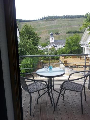 a table and chairs on a balcony with a view at Gaestehaus Jufferpanorama in Brauneberg