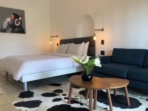 a bedroom with a bed and a couch and a table at Tempel Wines in Paarl