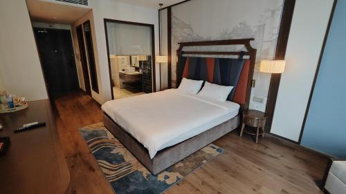 een slaapkamer met een groot wit bed in een kamer bij Apec Mandala Wyndham Phan Thiet - Mui Ne in Ấp Thiẹn Ái