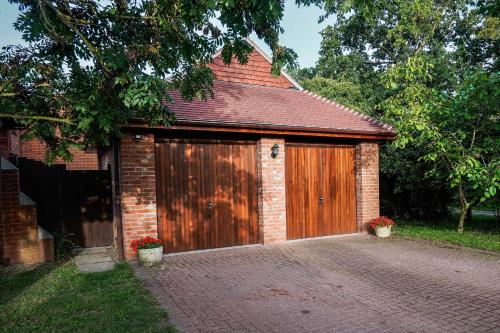a large wooden garage with a brick building at Spring Close in Colchester