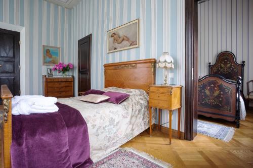 a bedroom with a bed and a table with a lamp at Burbiskio dvaras in Anykščiai