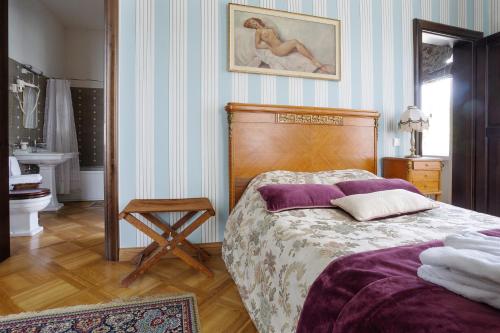 a bedroom with a bed and a bathroom with a sink at Burbiskio dvaras in Anykščiai