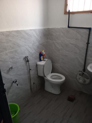 a bathroom with a toilet and a shower in it at Teratak Amani Hometay in Tawau