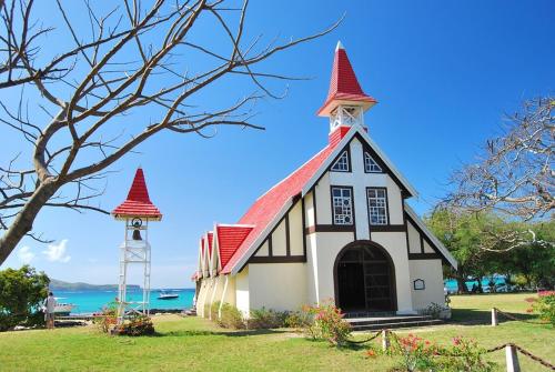 uma pequena igreja com um telhado vermelho e uma torre em Day tours around Mauritius island. (North, South, East, West) em Plaine Magnien