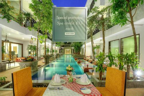 a restaurant with a swimming pool in a building at Golden Temple Retreat in Siem Reap