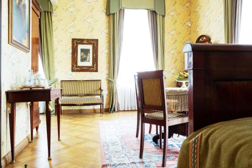 a bedroom with a bed and a desk and a chair at Burbiskio dvaras in Anykščiai