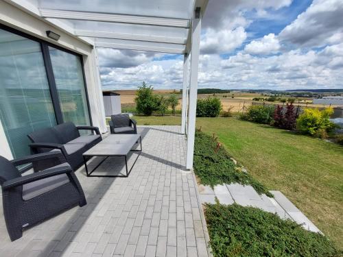 a patio with chairs and a table and a view of a field at Apartmán Polička in Polička