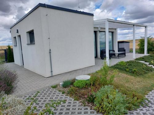 a white house with a patio with a table and chairs at Apartmán Polička in Polička