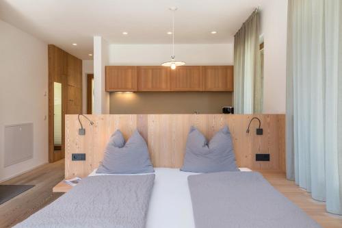 a bedroom with two beds with blue pillows at Vista Dolomites Apartment Liberty in Santa Cristina in Val Gardena