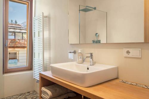 lavabo blanco en un baño con ventana en Vista Dolomites Apartment Liberty, en Santa Cristina Valgardena