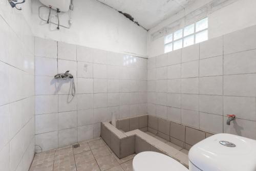 a bathroom with a toilet and a bath tub at Urbanview Hotel D'Pineapple Villa Ciater by RedDoorz in Subang