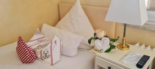 a bed with pillows and a lamp on a table at Hotel Villa Verde in Düsseldorf