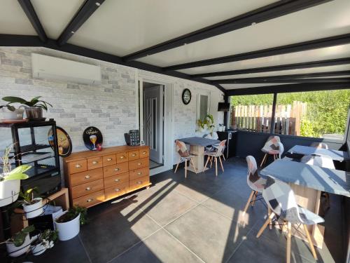 a patio with a table and chairs in a room at Au Ch'ti Suisse 