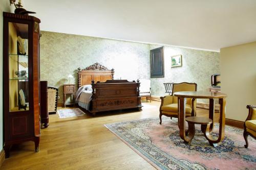 a bedroom with a bed and a table and a table sidx sidx sidx at Burbiskio dvaras in Anykščiai
