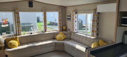 a living room with a couch and two windows at Ashdale By Sea in Whitstable