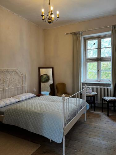 a bedroom with a white bed and a window at Gut Manderow an der Ostsee in Hohenkirchen