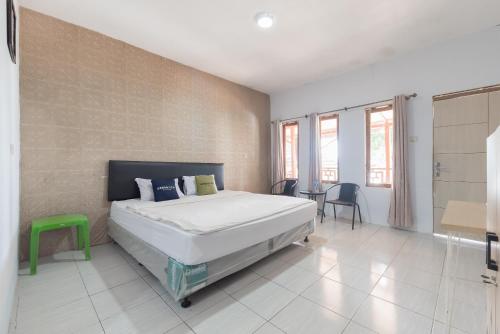 a bedroom with a bed and a table and chairs at Urbanview Hotel D'Pineapple Villa Ciater by RedDoorz in Subang
