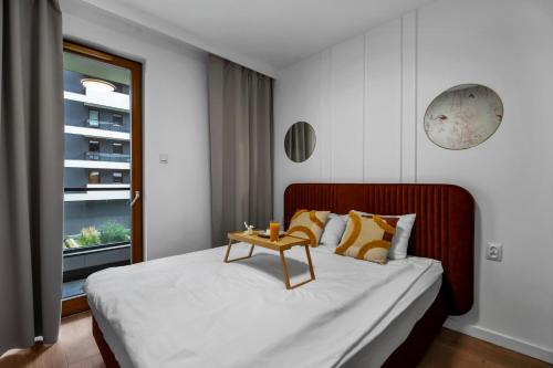 a bedroom with a bed with a table on it at Kasprzaka 29A Business Apartments N2 - Parking, Balcony, Targi Expo - by Rentujemy in Warsaw
