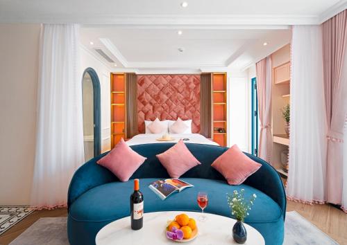 a hotel room with a bed and a blue couch at Pavillon Boutique Hotel & Apartment Nha Trang in Nha Trang