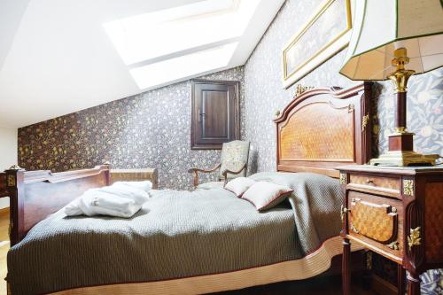 a bedroom with a bed and a table with a lamp at Burbiskio dvaras in Anykščiai