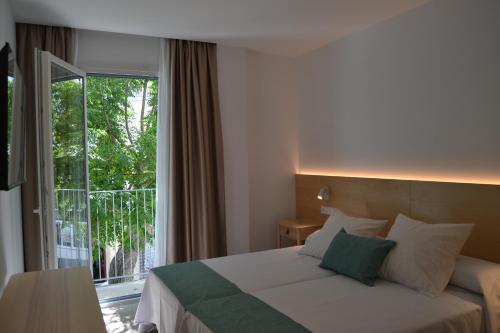 a bedroom with a bed and a large window at Hotel OASIS CENTRO in Conil de la Frontera
