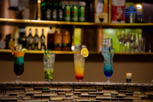 a row of different colored drinks on a bar at G-ONE HOTEL in Kampala