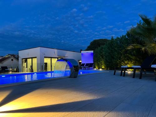 a villa with a swimming pool at night at Holiday Luxury Resort Sundance in Trogir