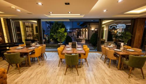 a restaurant with wooden tables and yellow chairs at Hotel & Restaurant Ponte Bianco in Vranje