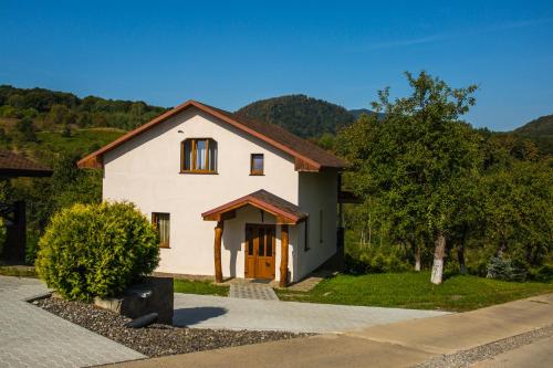 a white house with a brown door and trees at Шаян Гора in Shaian