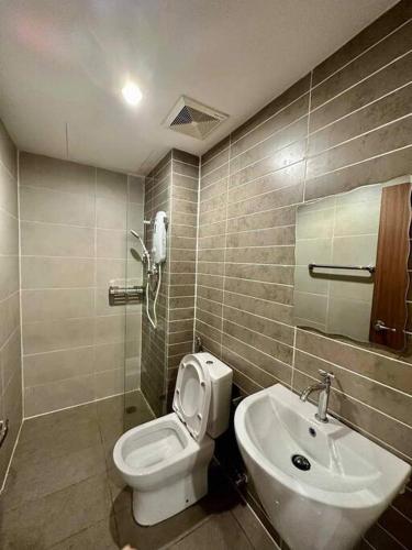 a bathroom with a toilet and a sink at Kuching Kozi Square Apartment III in Kuching