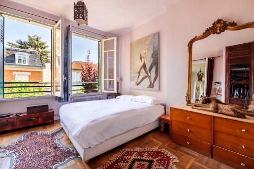 une chambre avec un grand lit et une grande fenêtre dans l'établissement Veeve - Eclectic Delights, à Paris