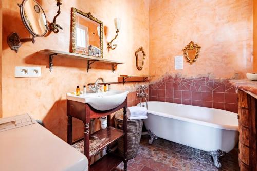 une salle de bain avec un lavabo, une baignoire et un miroir dans l'établissement Veeve - Eclectic Delights, à Paris
