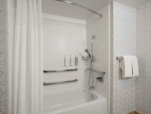 a bathroom with a bath tub with a shower curtain at Hampton Inn & Suites Arundel Mills/Baltimore in Hanover