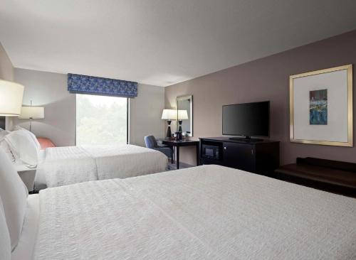 a hotel room with two beds and a flat screen tv at Hampton Inn & Suites Arundel Mills/Baltimore in Hanover